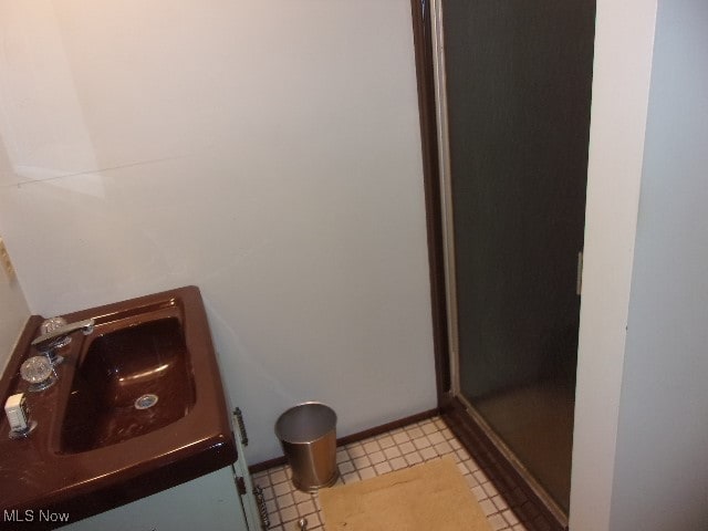 bathroom with vanity, tile patterned floors, and a shower with door