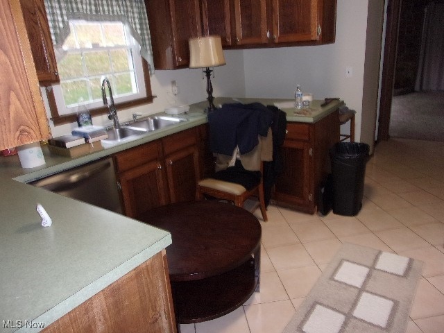 kitchen featuring light tile patterned flooring, sink, and dishwasher