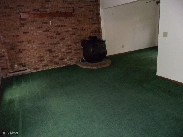 139 Melinda Dr, Wintersville, OH 43953 - unfurnished living room featuring carpet, a wood stove, and brick wall