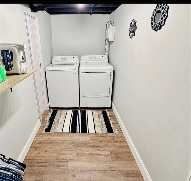 laundry area with wood-type flooring and washing machine and clothes dryer