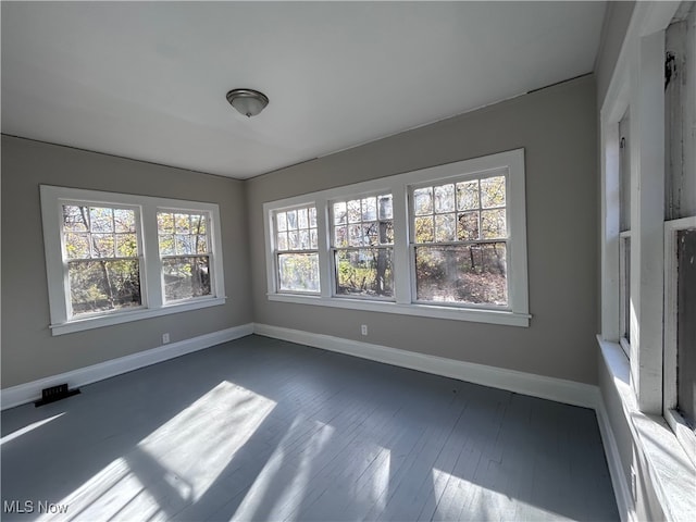 unfurnished room with dark wood-type flooring and plenty of natural light