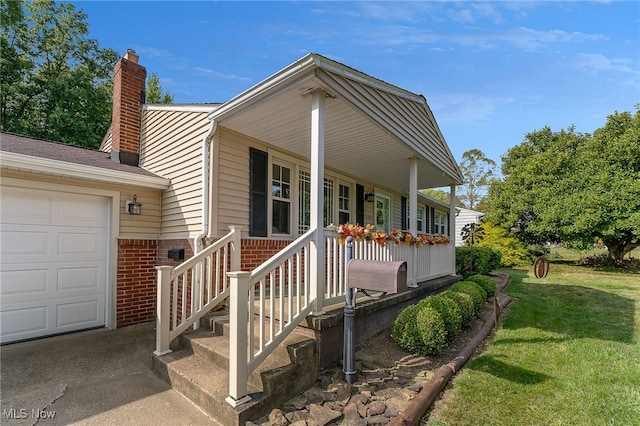 exterior space with a garage, a yard, and covered porch