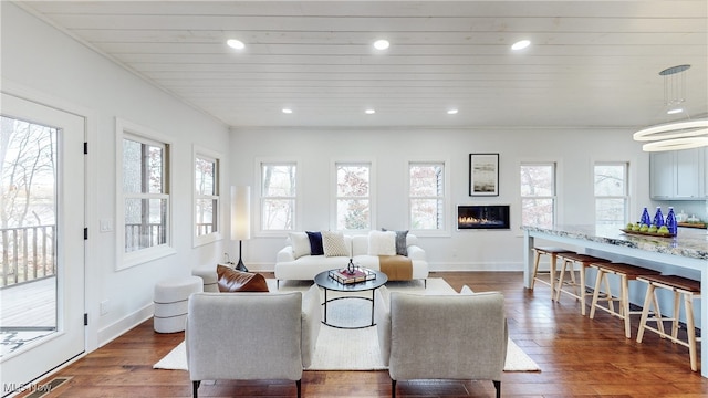 living room featuring wood ceiling, a healthy amount of sunlight, and dark hardwood / wood-style floors