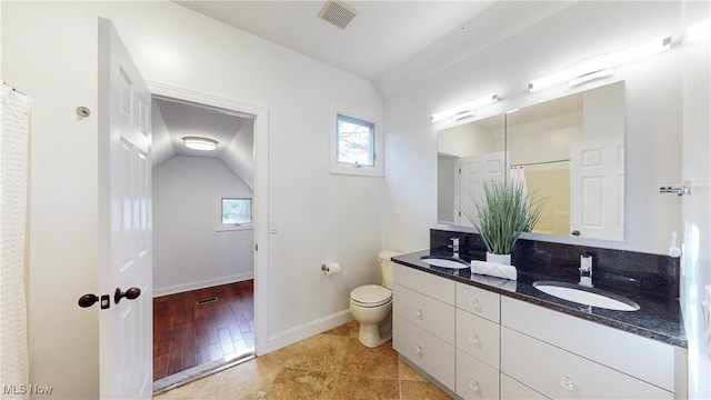 bathroom with wood-type flooring, vanity, toilet, and lofted ceiling