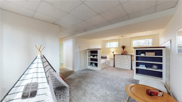 playroom featuring a paneled ceiling and carpet floors