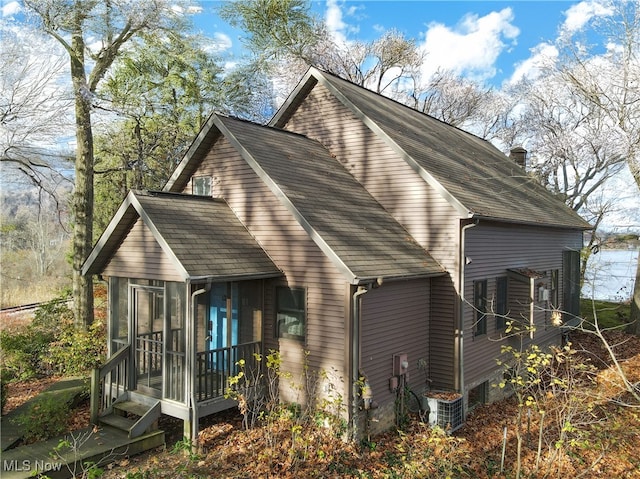 back of house featuring a sunroom and central AC