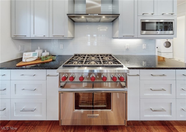 kitchen with stainless steel appliances, wall chimney exhaust hood, white cabinets, and dark hardwood / wood-style flooring