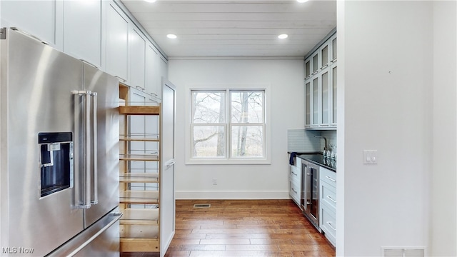 kitchen with dark wood-type flooring, high quality fridge, backsplash, and wine cooler