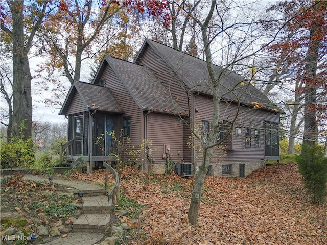 view of property exterior featuring a sunroom and cooling unit