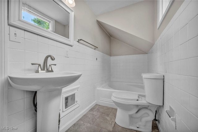 bathroom featuring tile walls, a bathing tub, and toilet