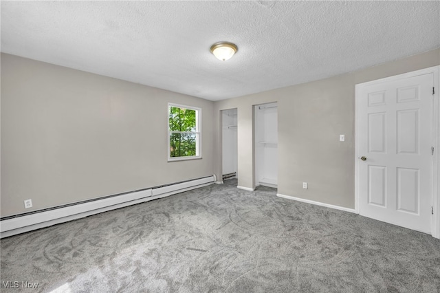 carpeted spare room featuring baseboard heating and a textured ceiling