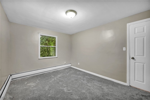 carpeted empty room featuring a baseboard heating unit