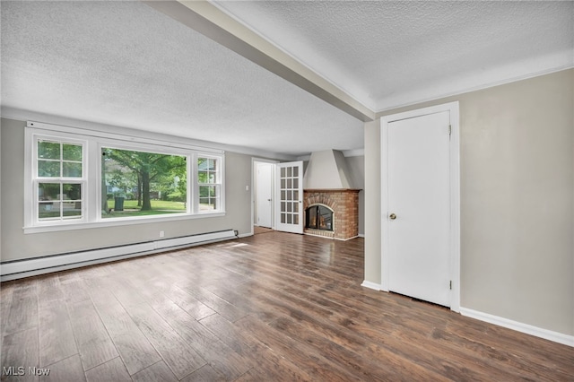 unfurnished living room with a brick fireplace, dark hardwood / wood-style floors, and a textured ceiling