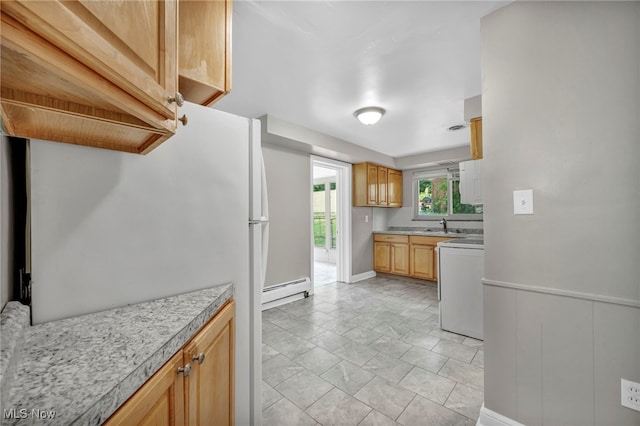 kitchen with a baseboard heating unit, sink, and white appliances