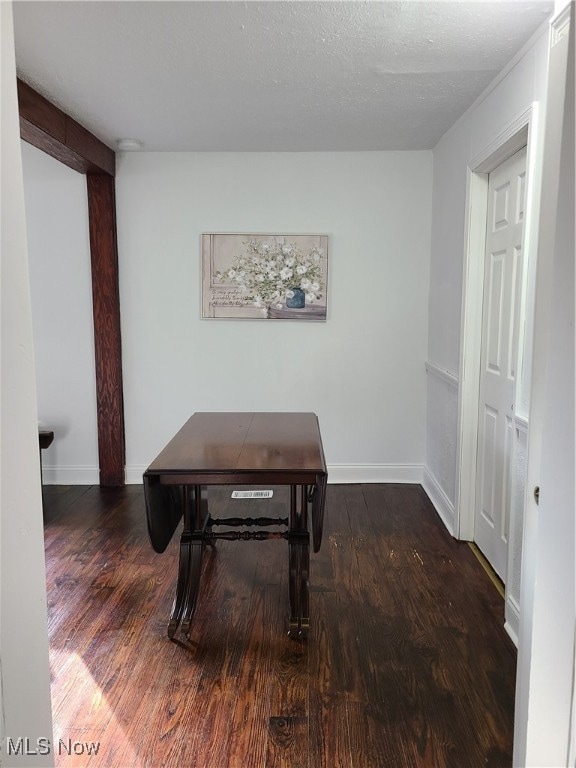 hall featuring a textured ceiling and dark hardwood / wood-style floors