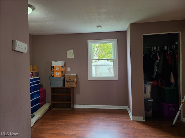 bedroom with dark wood-type flooring, a closet, and a textured ceiling