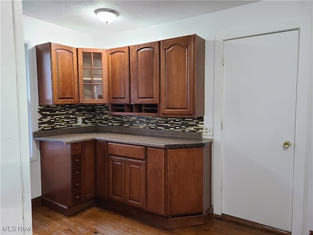 kitchen with hardwood / wood-style floors, a textured ceiling, and decorative backsplash