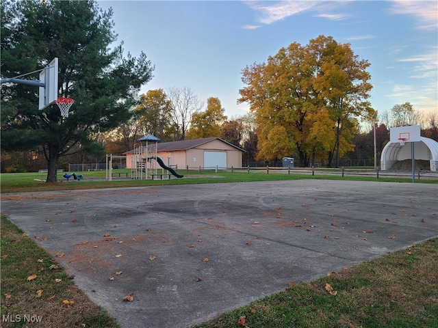 view of basketball court featuring a playground and a yard