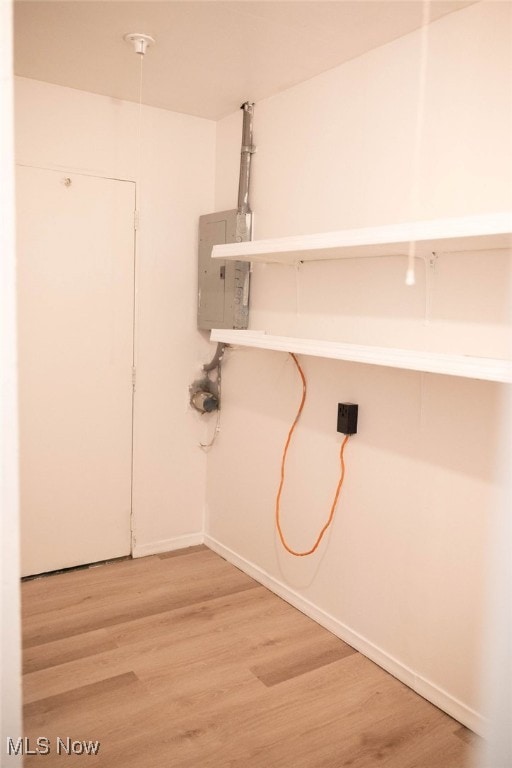 washroom featuring electric panel and wood-type flooring