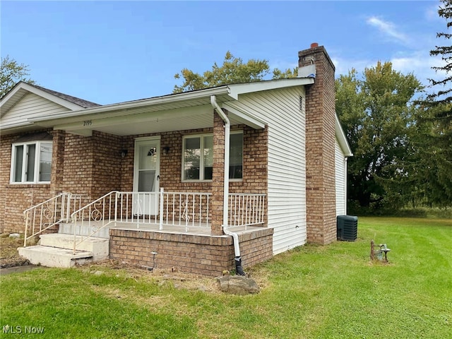 view of front of home featuring cooling unit and a front lawn