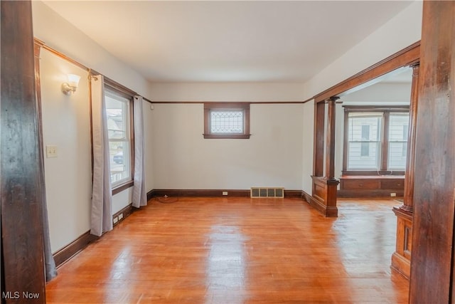 3594 W 49th St, Cleveland, OH 44102 - empty room with ornate columns, plenty of natural light, and light wood-style floors