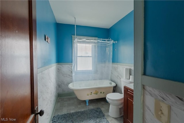 3594 W 49th St, Cleveland, OH 44102 - bathroom with a wainscoted wall, a soaking tub, tile walls, and toilet