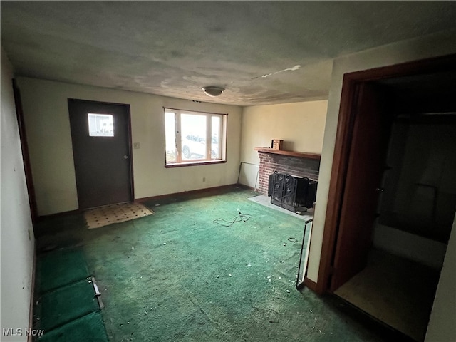 unfurnished living room with a brick fireplace and carpet