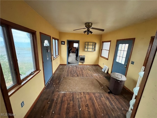 interior space featuring ceiling fan, heating unit, and dark hardwood / wood-style flooring