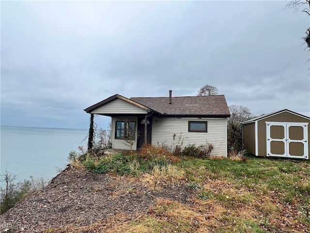 view of front of house featuring a water view and a storage unit