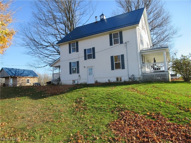 back of property featuring a porch and a lawn