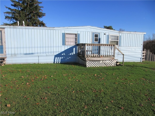 back of property with a lawn and a wooden deck