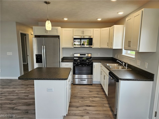 kitchen with white cabinetry, sink, a kitchen island, and appliances with stainless steel finishes