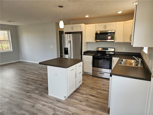 kitchen featuring a center island, white cabinetry, sink, and appliances with stainless steel finishes