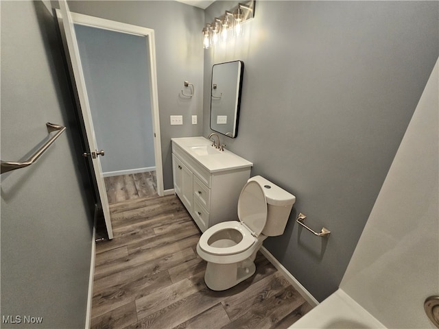 bathroom with hardwood / wood-style flooring, vanity, and toilet