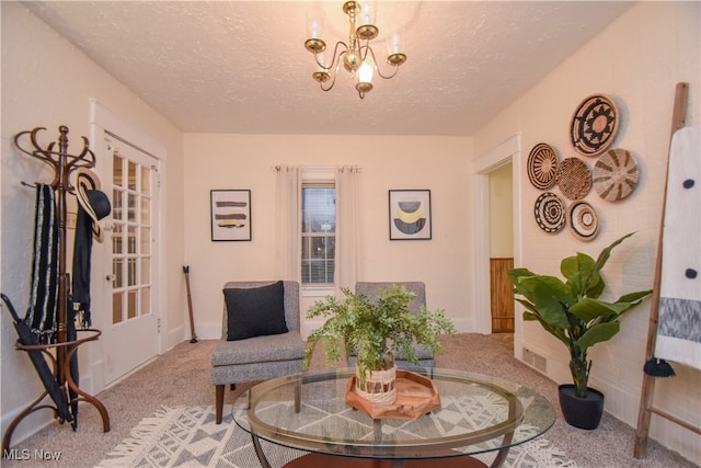 living area with carpet, a textured ceiling, and a notable chandelier