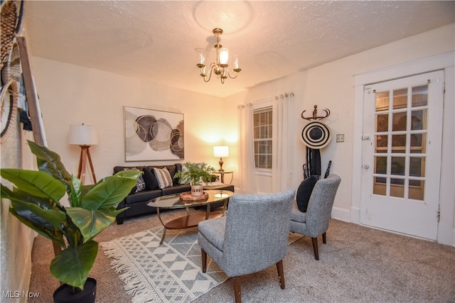 sitting room with a chandelier, a textured ceiling, and carpet