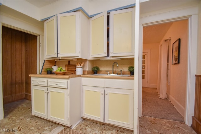 kitchen featuring white cabinetry, sink, and backsplash