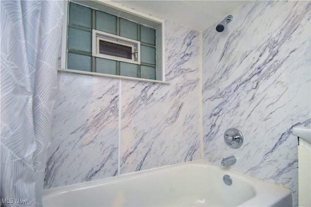 bathroom with shower / tub combo with curtain and tile walls