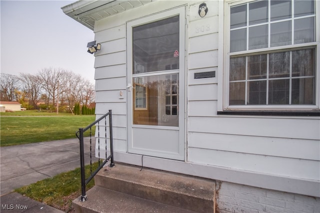 doorway to property featuring a lawn