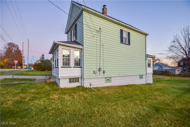 property exterior at dusk with a yard