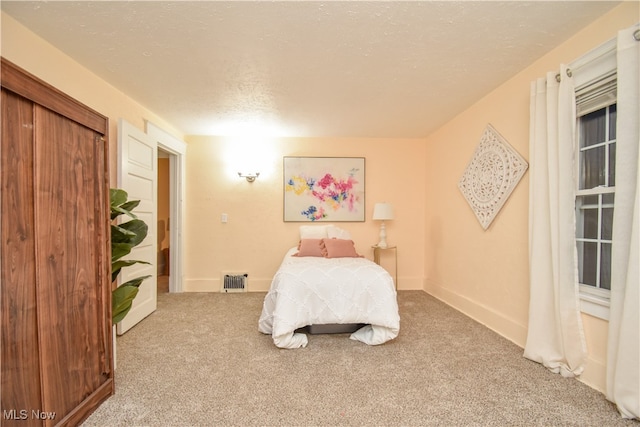 carpeted bedroom with a textured ceiling