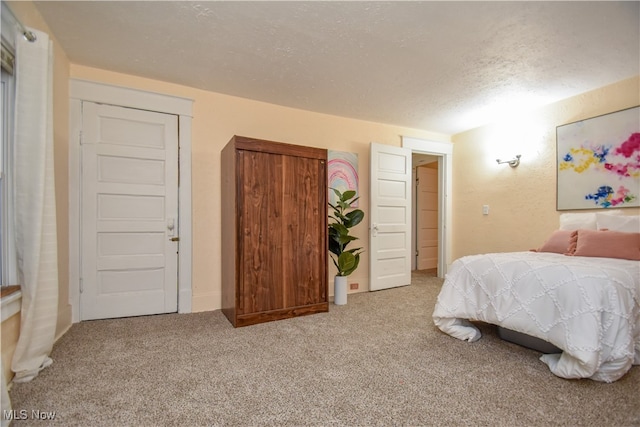 bedroom with a textured ceiling and light carpet