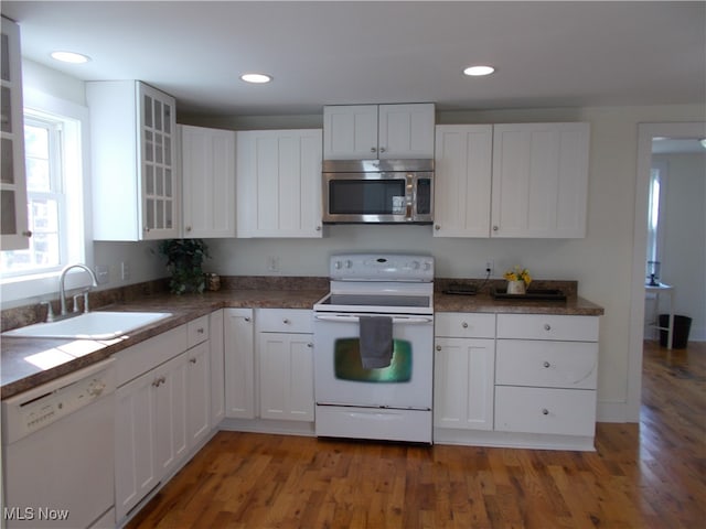 kitchen featuring white appliances, dark hardwood / wood-style floors, white cabinetry, and sink