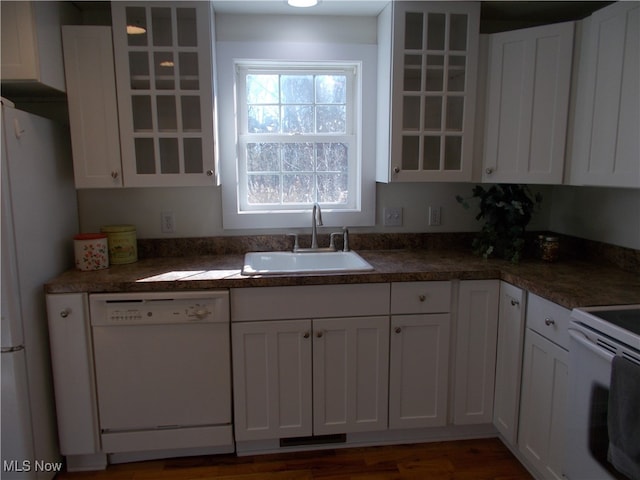 kitchen with dark wood-type flooring, white appliances, white cabinetry, and sink