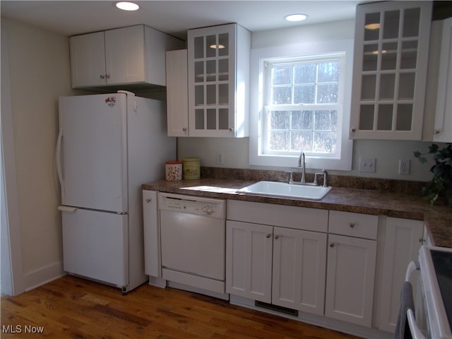 kitchen featuring white cabinets, dark wood-type flooring, sink, and white appliances