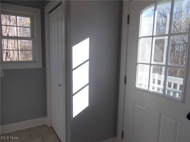 doorway to outside with light tile patterned floors