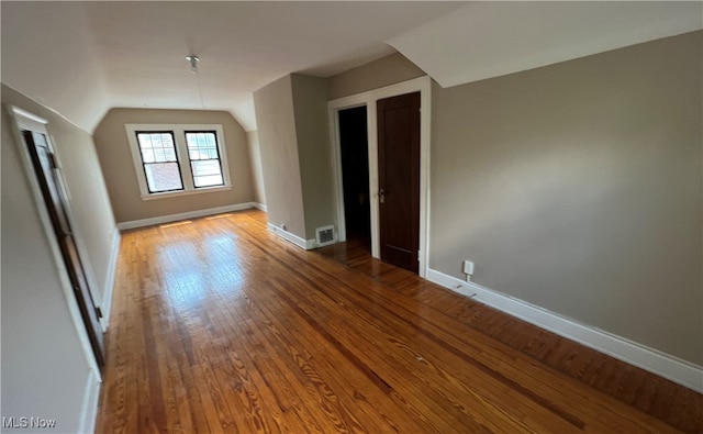 additional living space with light wood-type flooring and lofted ceiling