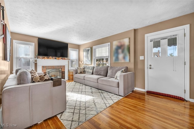 living room featuring a fireplace, light hardwood / wood-style floors, and a textured ceiling