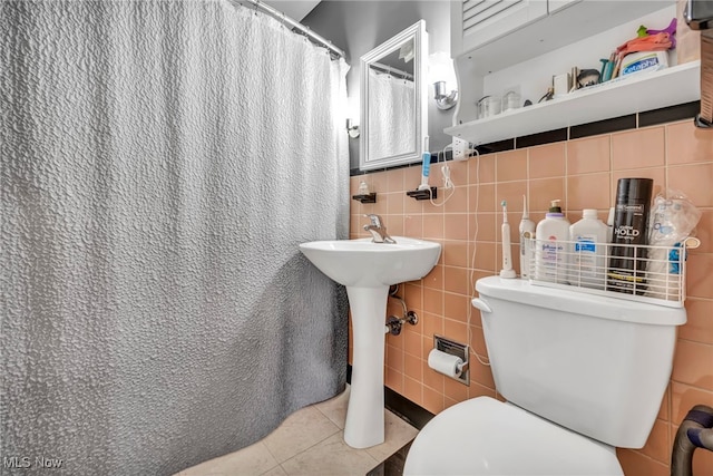 bathroom featuring a shower with curtain, tile patterned flooring, tile walls, and toilet