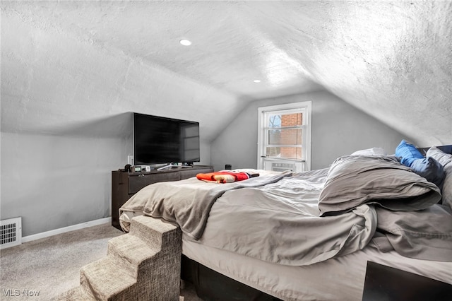 bedroom with carpet flooring, a textured ceiling, and vaulted ceiling